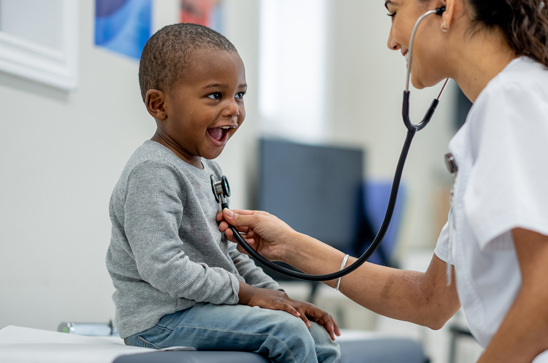 A little boy gets his heart listened with with a stethoscope by a doctor.