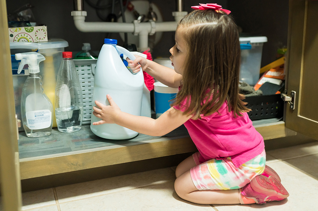 A little girl grabs a judge of bleach